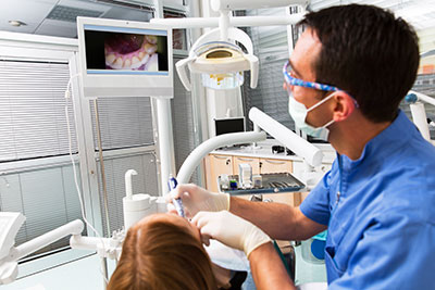 Dentist viewing a patient's teeth in intraoral camera at Surf City Oral and Maxillofacial Surgery in Huntington Beach, CA