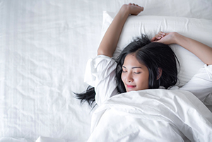 A woman stretching after a good night sleep