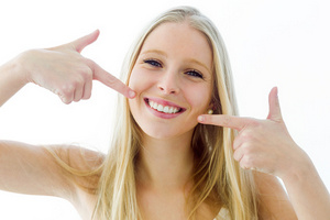 A woman smiling showing her white teeth