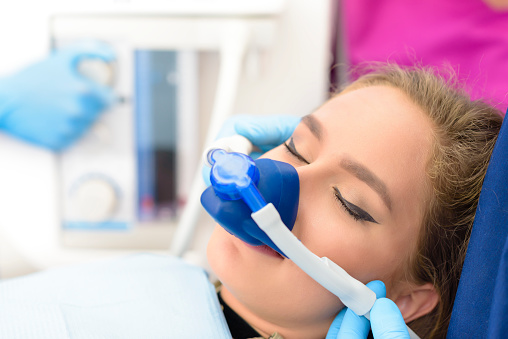 A woman being sedated on a dental chair