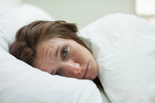 Depressed looking woman trying to sleep